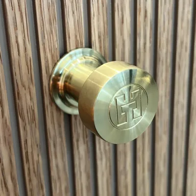 Hassel&Teudt HKN01L - Møbelgreb med H&T logo, PVD Børstet Messing
