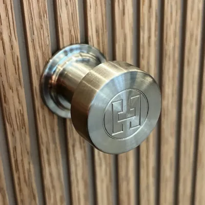 Hassel&Teudt HKN01L - Møbelgreb med H&T logo, PVD Børstet Stål